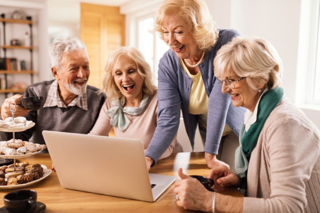Buda Oaks | Happy group of seniors using a laptop