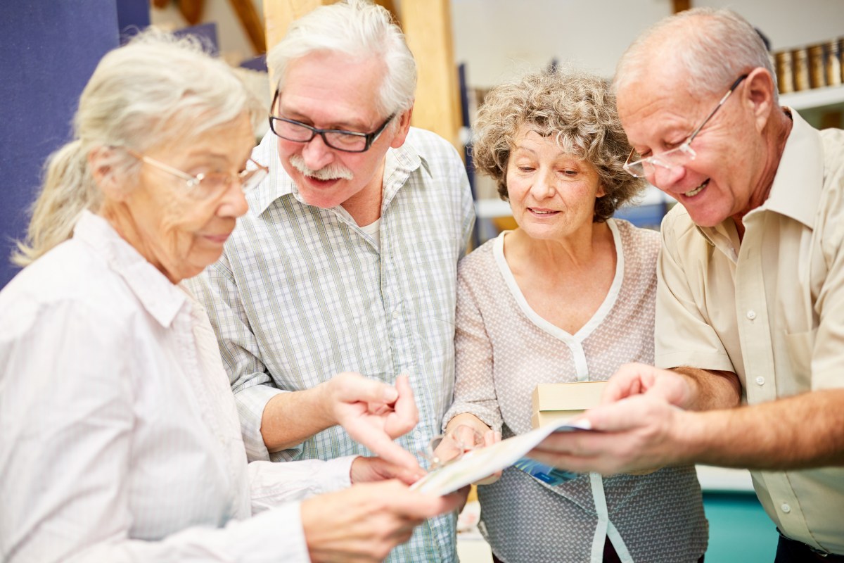 Buda Oaks | Group of Seniors Looking Through a Book