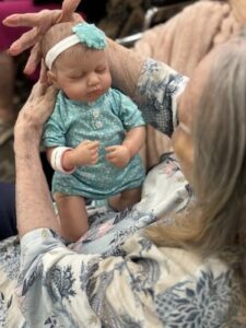 Buda Oaks | Senior woman holding a baby doll for therapy